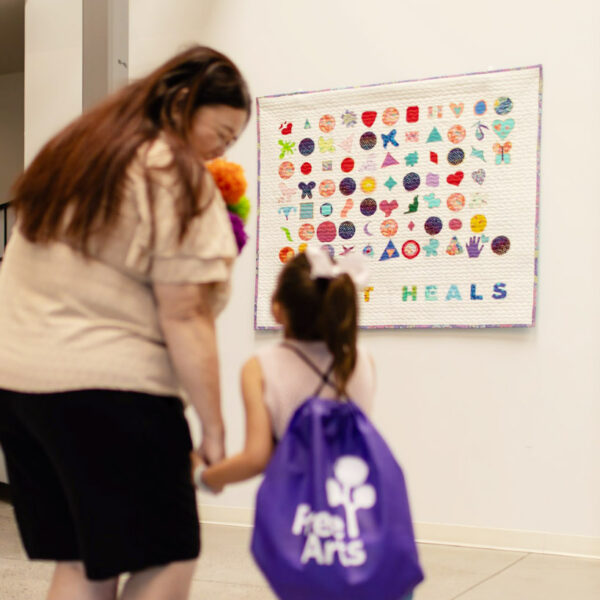 Art Heals quilt Mother and daughter looking at Art Heals quilt.